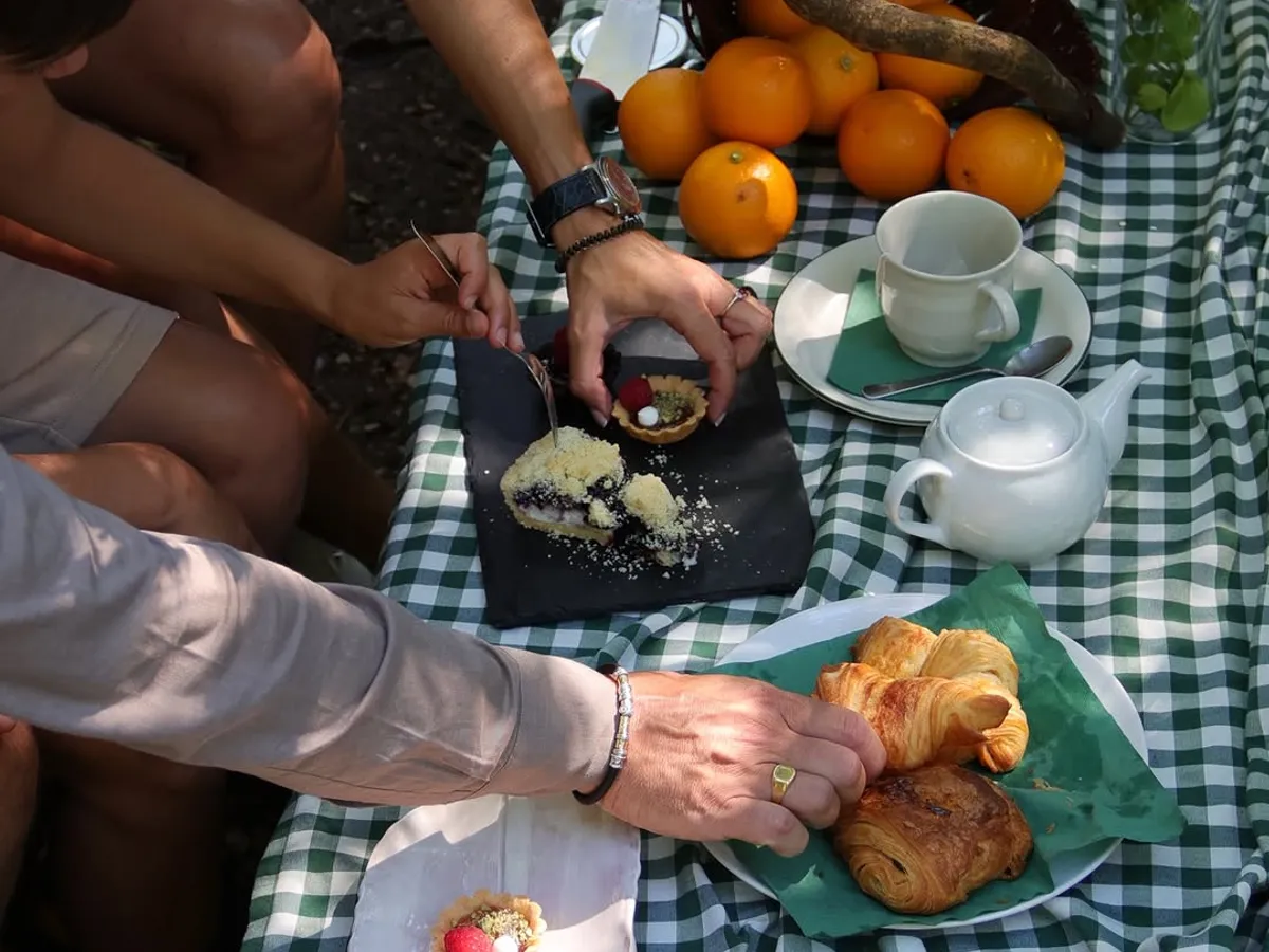 Cestino da picnic su una tovaglia a quadretti nel prato del parco